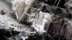 Extreme close-up of asbestos mineral fibers in damaged material central to mesothelioma injury claims