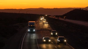 big_rig_truck_Oct_2025.jpgA big rig truck drives among highway traffic at twilight.