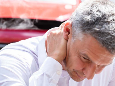 A man suffers from neck pain after a car accident injury.