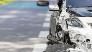 The front end of a white sedan displays significant damage after a wreck, indicating the dangers of car accidents on Texas roads.