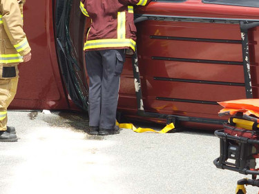 Emergency responders work around an overturned SUV at the scene of a serious crash, highlighting the reality of deaths from road accidents.