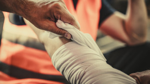 Construction worker receiving wrist bandaging after sustaining a workplace personal injury