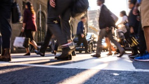 Crowd of pedestrians crossing a busy city intersection at ground level, illustrating urban pedestrian accident exposure