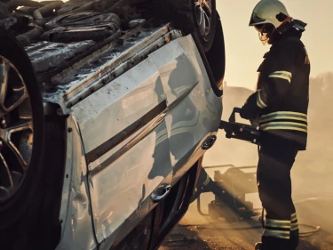 Roll over auto accident with fireman cutting open the car door