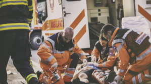 Paramedics and firefighter providing emergency care to accident victim at personal injury scene