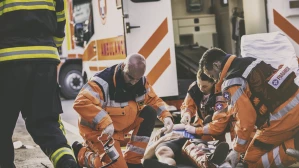 Paramedics and firefighter providing emergency care to accident victim at personal injury scene