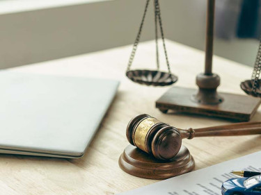 A desk with a gavel and scales of justice, representing the legal aid lawyers for car wrecks can offer their clients.