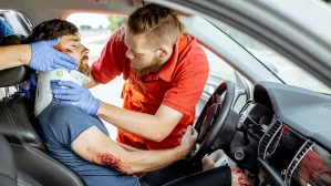 Paramedics place a neck brace on an injured driver after a motor vehicle accident.