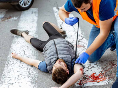An emergency responder attending to the victim of a Houston pedestrian accident.