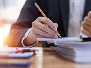 A lawyer sitting at a desk reviews files for personal injury cases.