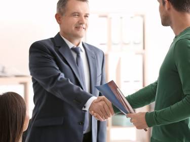 A couple shaking hands with an attorney from a reputable and reliable personal injury law firm to help them fight for justice and fair compensation.