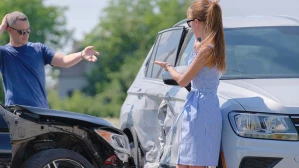 A man and a woman argue about who’s at fault for an auto accident, a matter a rideshare accident lawyer could help resolve.