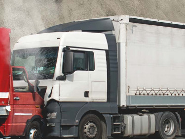 A head-on collision between a semitruck and a smaller delivery truck.