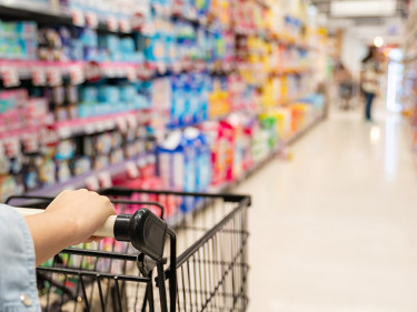 Shopper pushing cart through retail store aisle representing slip and fall accident premises liability