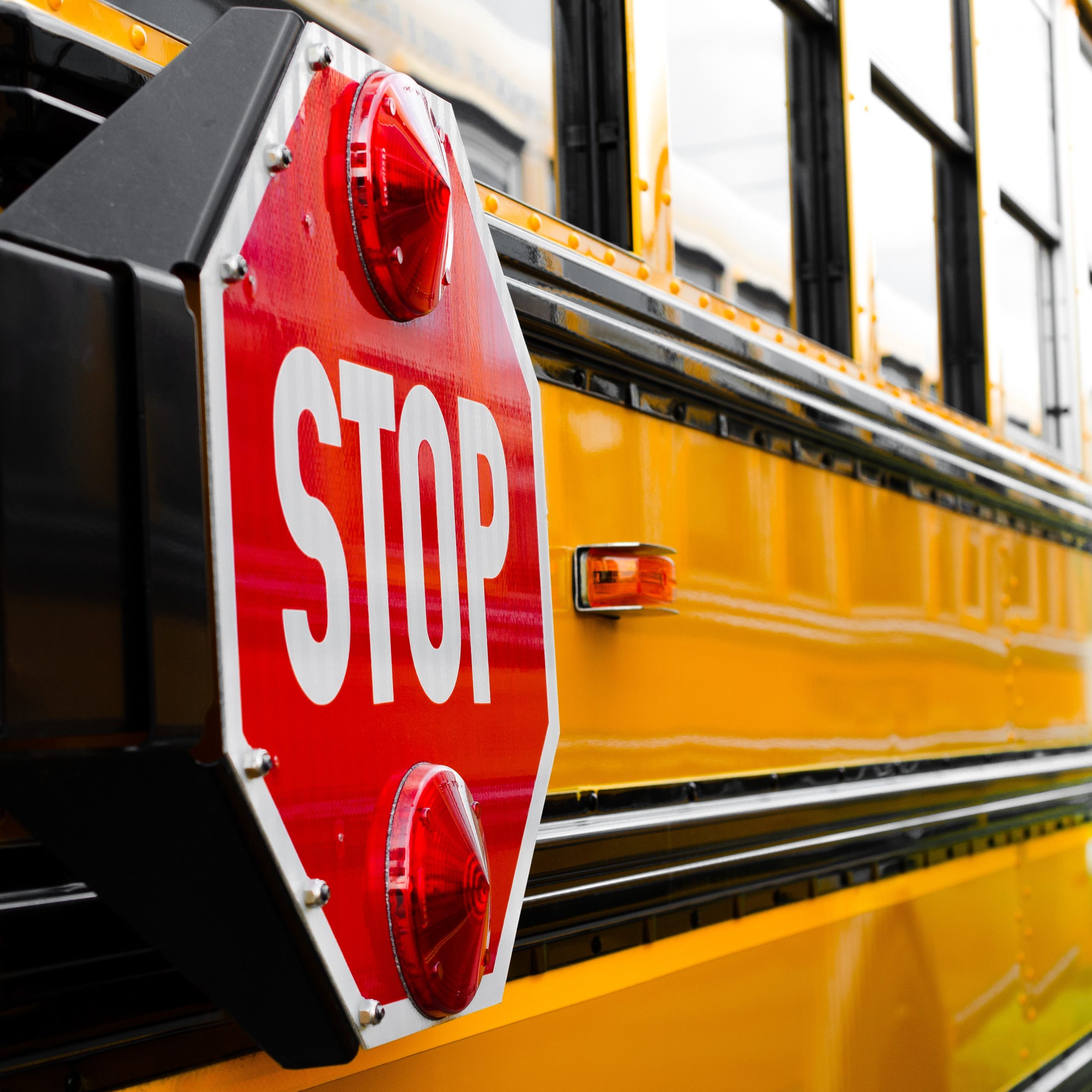 yellow school bus with red stop sign